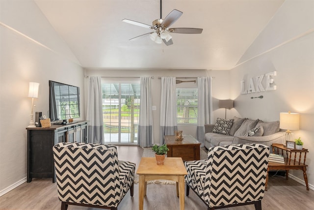 living area featuring baseboards, vaulted ceiling, ceiling fan, and light wood-style floors