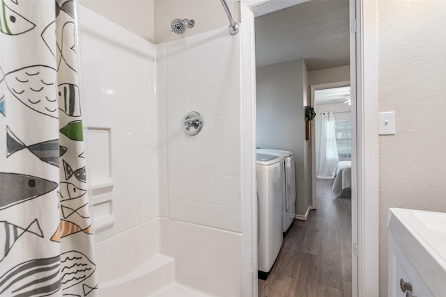 full bath featuring separate washer and dryer, curtained shower, wood finished floors, and vanity