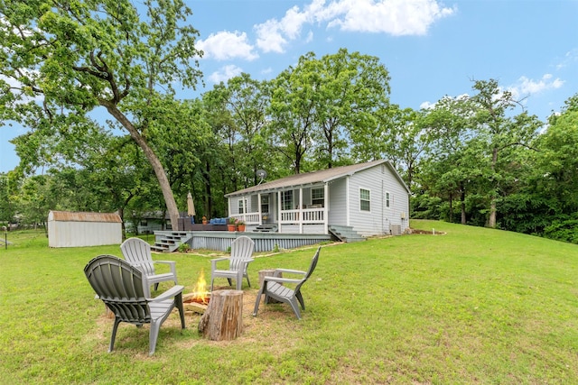 view of yard with a storage shed, an outbuilding, an outdoor fire pit, and a deck