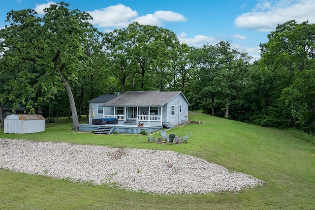 back of house with a lawn, an outbuilding, a shed, and a wooden deck