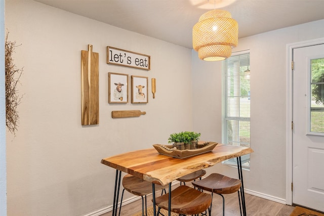 dining room with baseboards and light wood finished floors