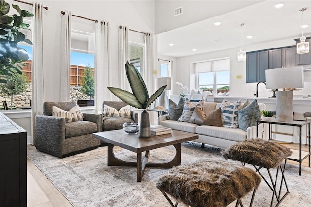 living area with recessed lighting, visible vents, and light wood-type flooring