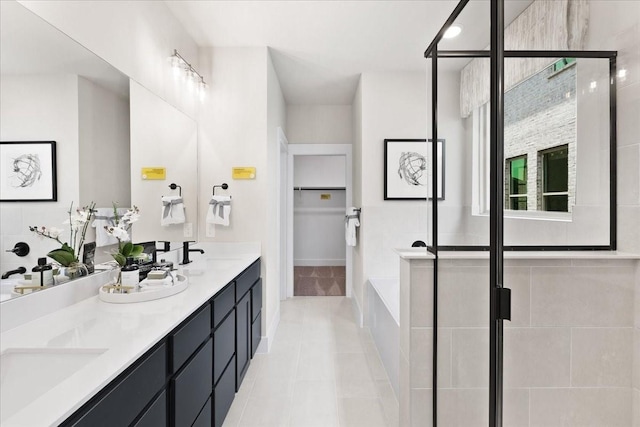 bathroom with a shower stall, a sink, and tile patterned flooring