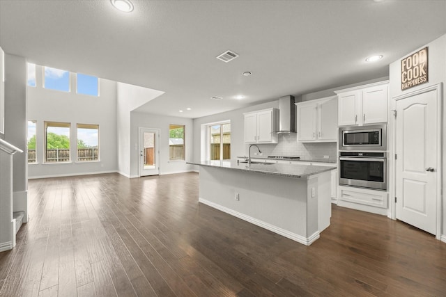 1617 Beauregard Point Dr, Wylie, TX 75098 - kitchen with appliances with stainless steel finishes, a sink, wall chimney exhaust hood, open floor plan, and visible vents
