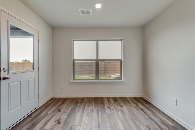 interior space with light wood-style floors, baseboards, and visible vents