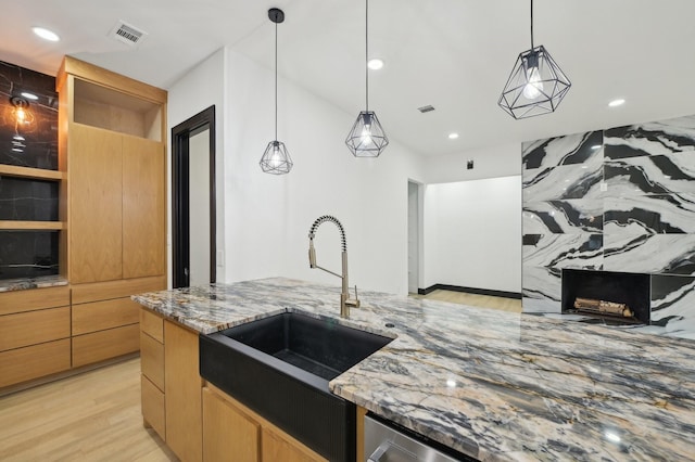 4219 Hollow Oak Dr, Dallas, TX 75287 - kitchen with light stone countertops, recessed lighting, a sink, light wood finished floors, and hanging light fixtures