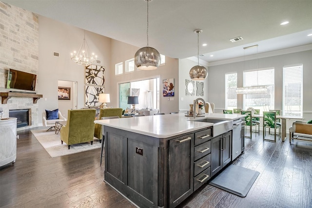 kitchen with a stone fireplace, a sink, open floor plan, and light countertops