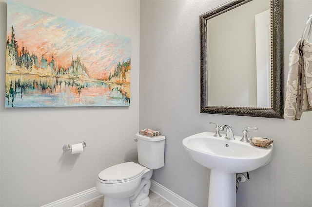 bathroom featuring baseboards and toilet