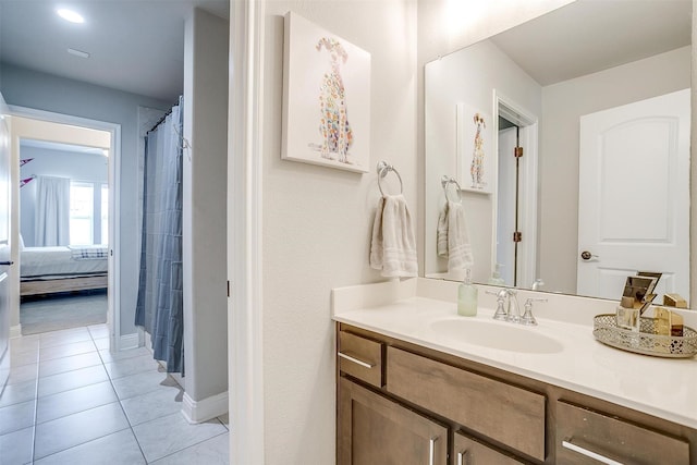 full bath with baseboards, ensuite bathroom, tile patterned flooring, and vanity