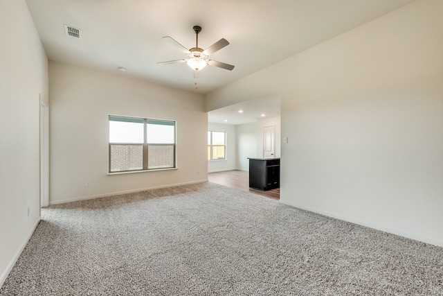 unfurnished living room with a ceiling fan, visible vents, baseboards, carpet flooring, and recessed lighting