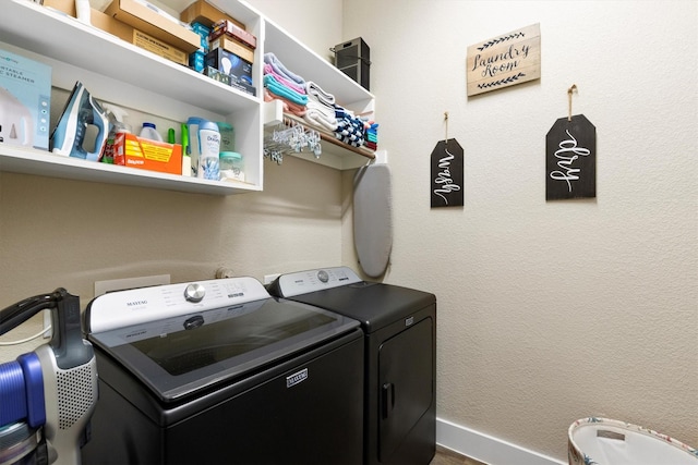 clothes washing area featuring laundry area, washer and clothes dryer, and baseboards