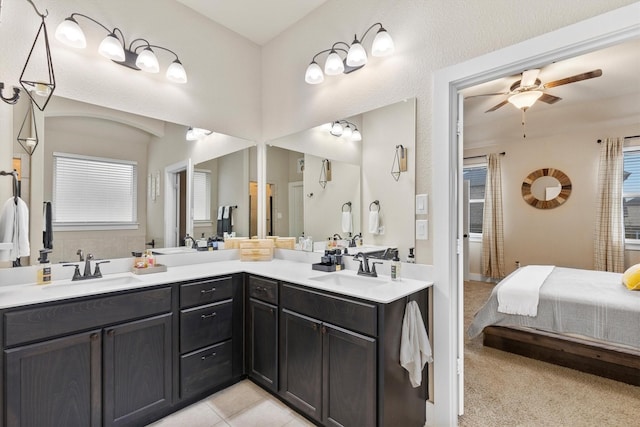 ensuite bathroom with double vanity, a sink, a ceiling fan, and ensuite bathroom