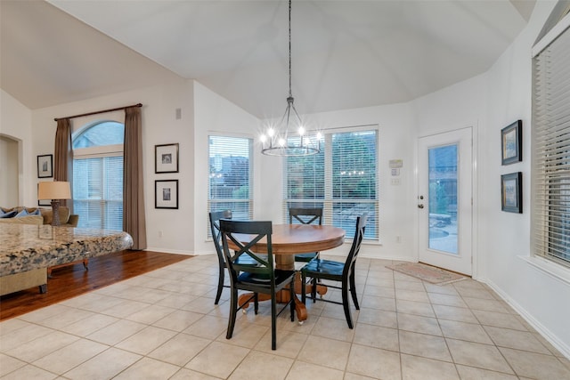 dining room featuring light tile patterned flooring, a chandelier, and lofted ceiling