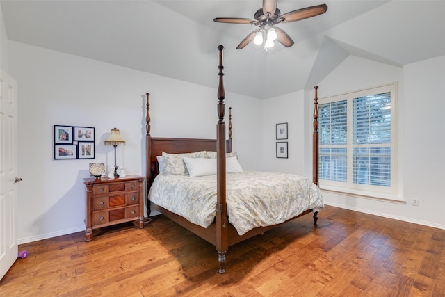 bedroom featuring a ceiling fan, baseboards, vaulted ceiling, and light wood finished floors