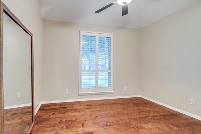 empty room with baseboards, a ceiling fan, and wood finished floors