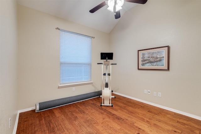 exercise area with baseboards, a ceiling fan, wood finished floors, and lofted ceiling