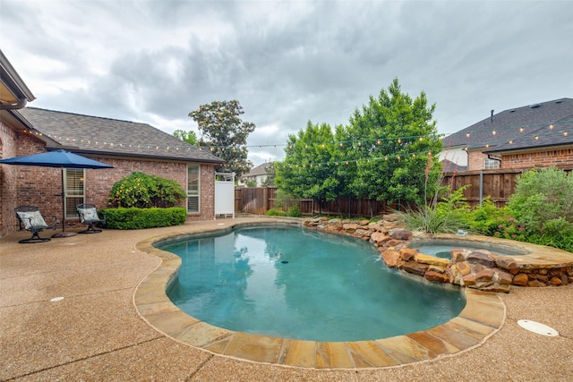 view of pool with a patio, a pool with connected hot tub, and a fenced backyard