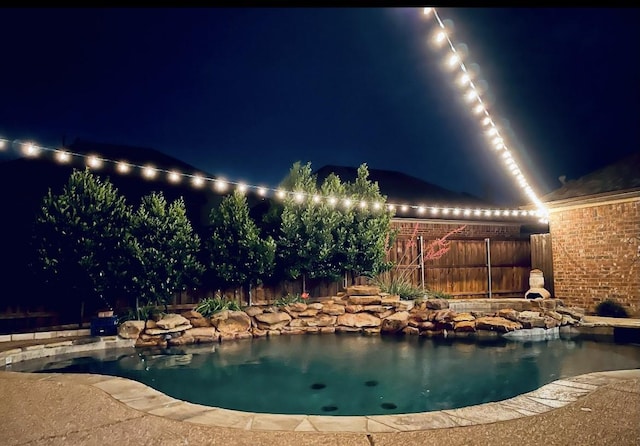 pool at twilight with fence and a fenced in pool