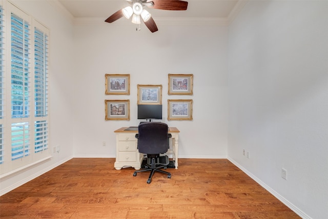 office space featuring crown molding, a ceiling fan, baseboards, and light wood-style floors