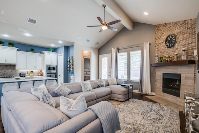 3504 Perkins Ln, Mckinney, TX 75072 - living room featuring a ceiling fan, visible vents, wood finished floors, and a tile fireplace
