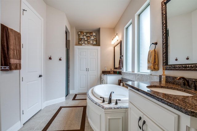 3504 Perkins Ln, Mckinney, TX 75072 - bathroom featuring a sink, tile patterned floors, baseboards, two vanities, and a garden tub