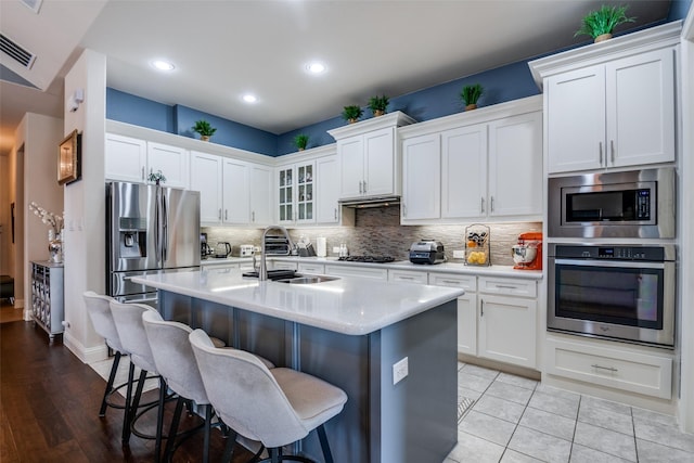 3504 Perkins Ln, Mckinney, TX 75072 - kitchen with a breakfast bar area, light countertops, a sink, appliances with stainless steel finishes, and backsplash