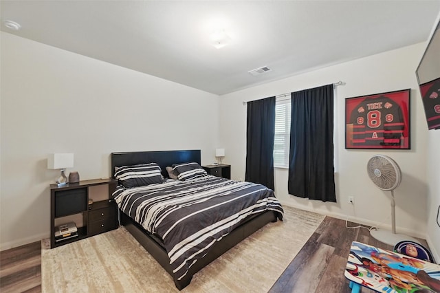 bedroom featuring wood finished floors and baseboards