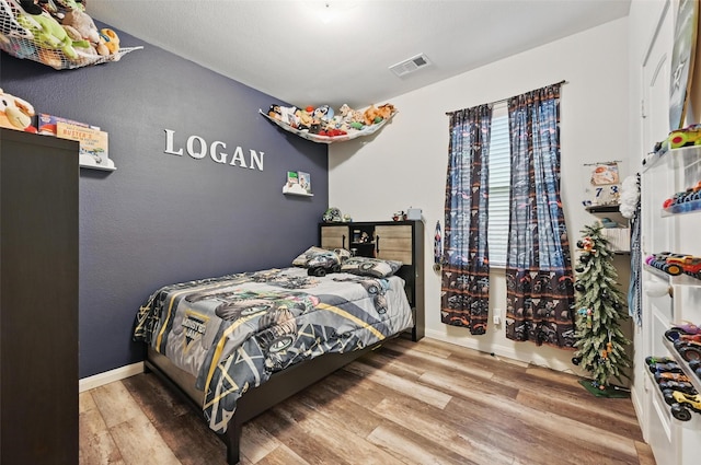 bedroom with wood finished floors and baseboards