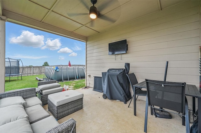 view of patio / terrace featuring a trampoline, outdoor lounge area, a ceiling fan, and an outdoor pool
