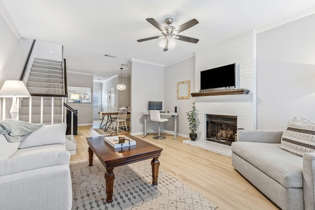 3801 14th St Unit 1607, Plano, TX 75074 - living room with ornamental molding, stairs, a brick fireplace, a ceiling fan, and light wood-style flooring