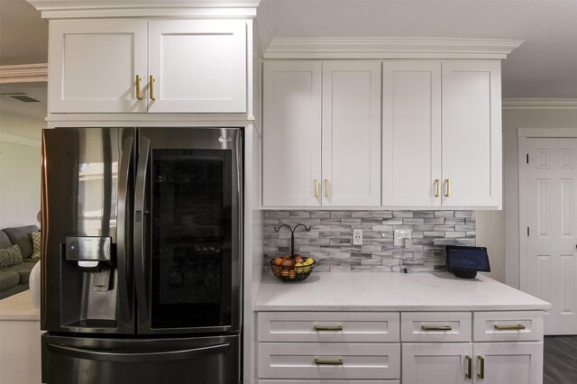 kitchen with ornamental molding, decorative backsplash, black refrigerator with ice dispenser, and white cabinetry