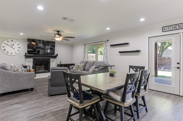 dining room with ornamental molding, ceiling fan, and wood finished floors