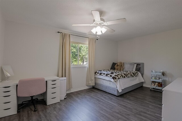 bedroom with a ceiling fan, a textured ceiling, and dark wood-type flooring