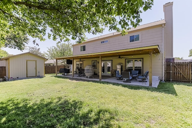 back of house with french doors, a ceiling fan, a lawn, and a fenced backyard