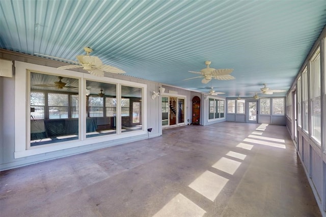 unfurnished sunroom featuring ceiling fan