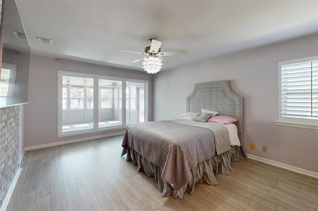bedroom featuring visible vents, multiple windows, and light wood finished floors