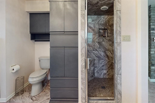 bathroom with baseboards, a stall shower, and toilet