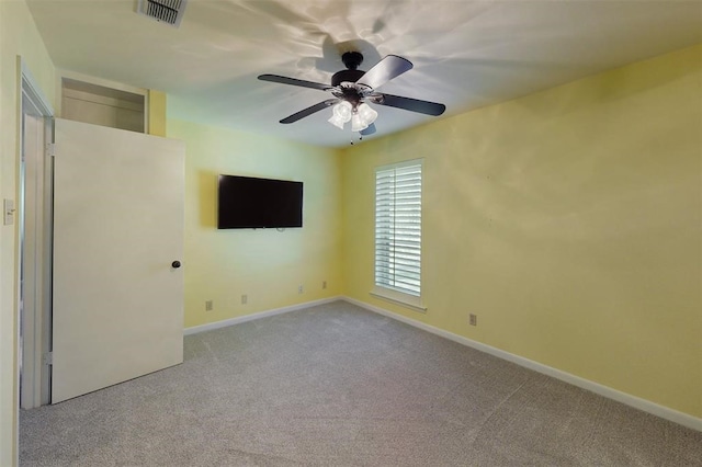 carpeted empty room with visible vents, baseboards, and ceiling fan