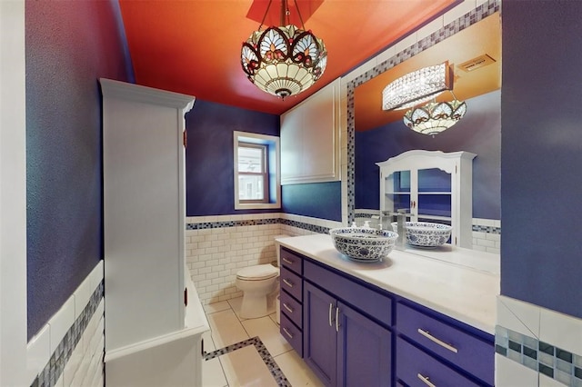 bathroom featuring vanity, tile patterned floors, toilet, and an inviting chandelier