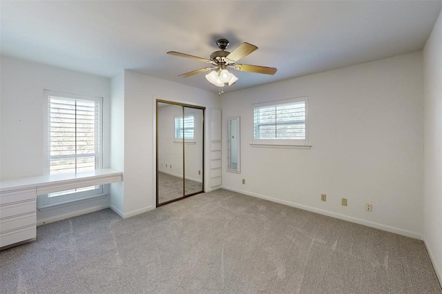 unfurnished bedroom featuring baseboards, a closet, and light carpet