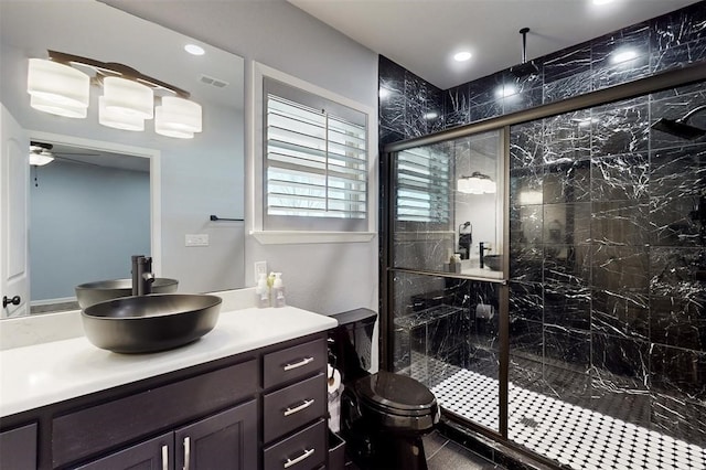 full bath featuring visible vents, vanity, toilet, a ceiling fan, and a marble finish shower