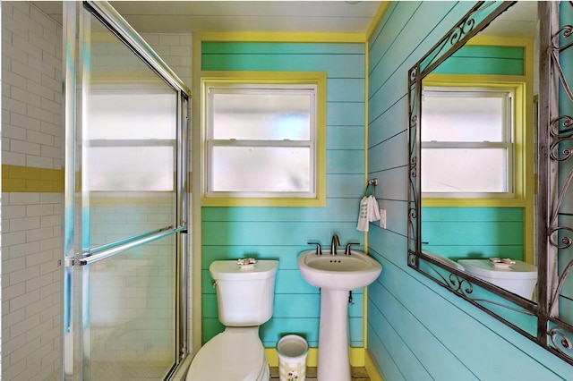 bathroom featuring toilet and a shower stall