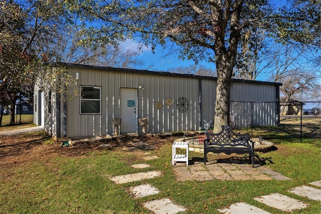 view of outbuilding featuring fence and an outbuilding