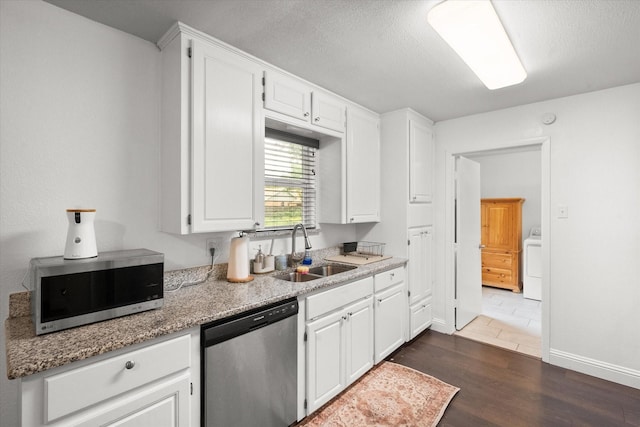 233 NE Moody St, Burleson, TX 76028 - kitchen featuring dark wood-style flooring, washer / clothes dryer, a sink, white cabinets, and stainless steel appliances