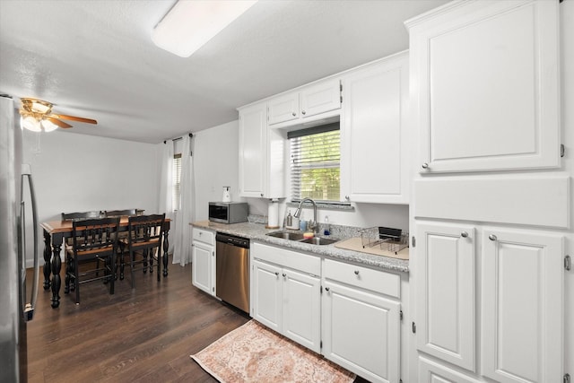 233 NE Moody St, Burleson, TX 76028 - kitchen with dark wood-type flooring, light countertops, white cabinetry, a sink, and appliances with stainless steel finishes