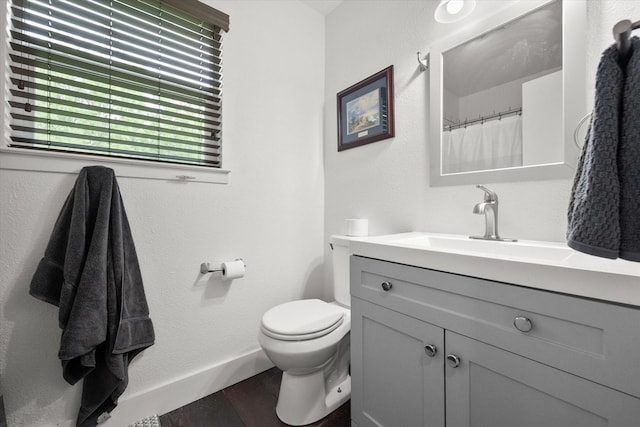 233 NE Moody St, Burleson, TX 76028 - full bathroom with vanity, baseboards, toilet, and wood finished floors