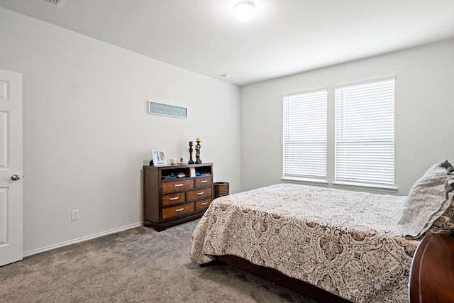 bedroom with baseboards and carpet