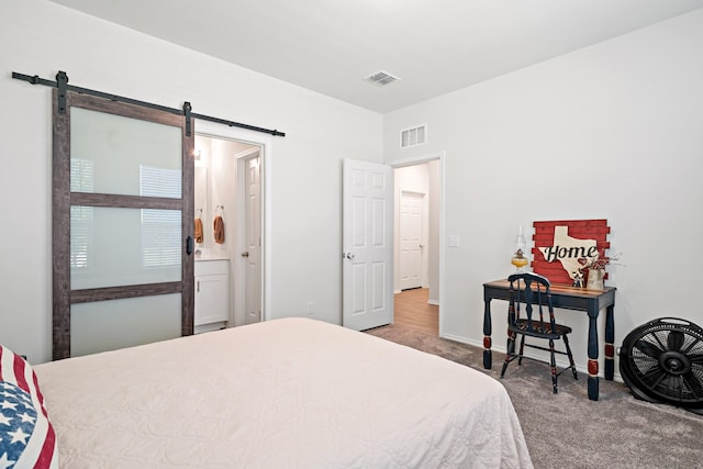 carpeted bedroom with baseboards, a barn door, and visible vents