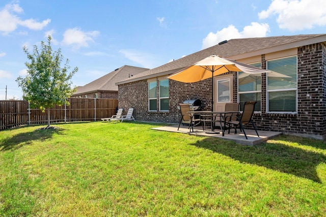 back of property with a fenced backyard, a yard, a patio area, and brick siding