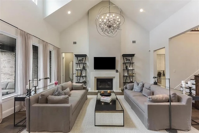 904 Devonshire Dr, Allen, TX 75013 - living room featuring visible vents, a glass covered fireplace, high vaulted ceiling, and an inviting chandelier